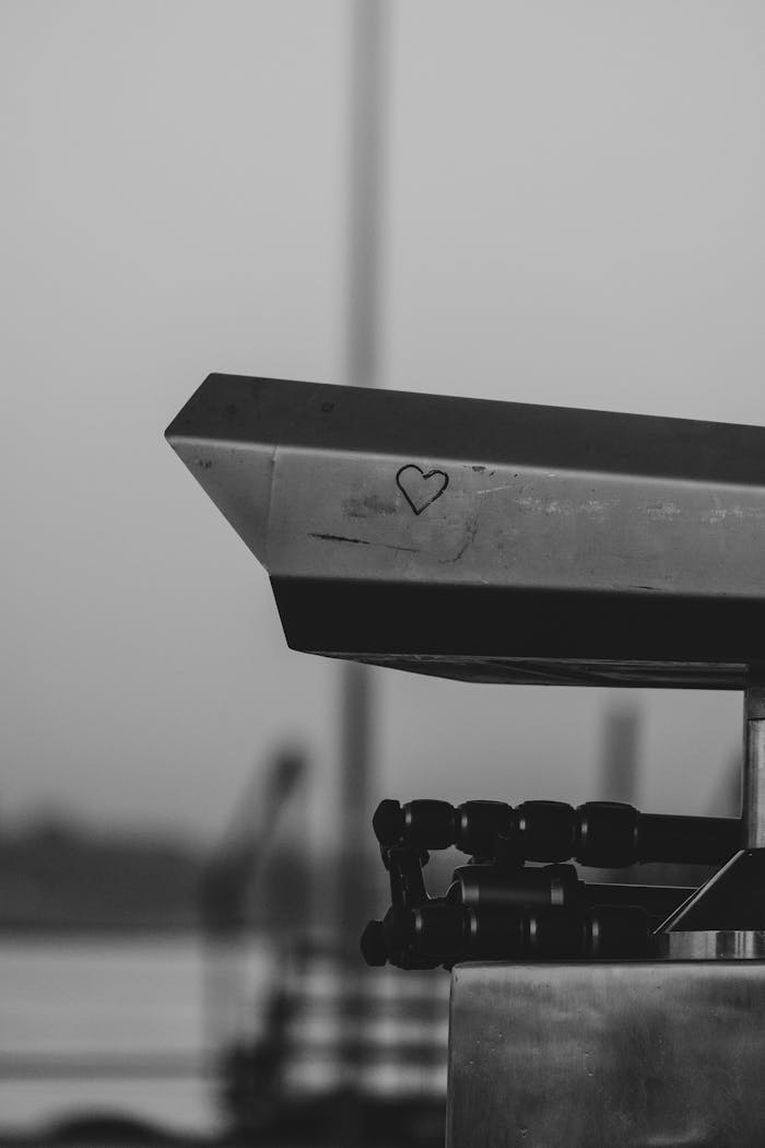 Close-up of industrial machinery with a heart engraving, captured in monochrome tones.
